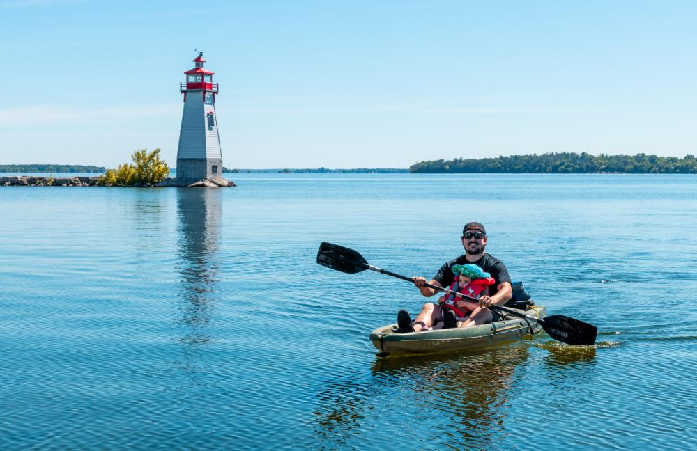 paddler on lake with lighthouse in background