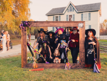 group of women dressed as witches standing within a wooden frame
