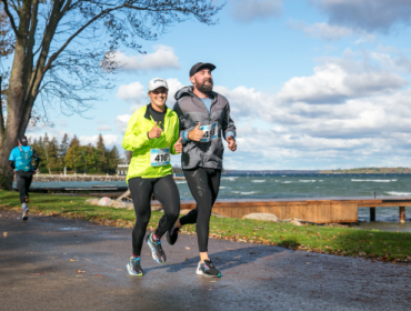 two people running a race along the lake 