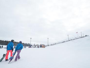 snowboarders at bottom of snowy hill
